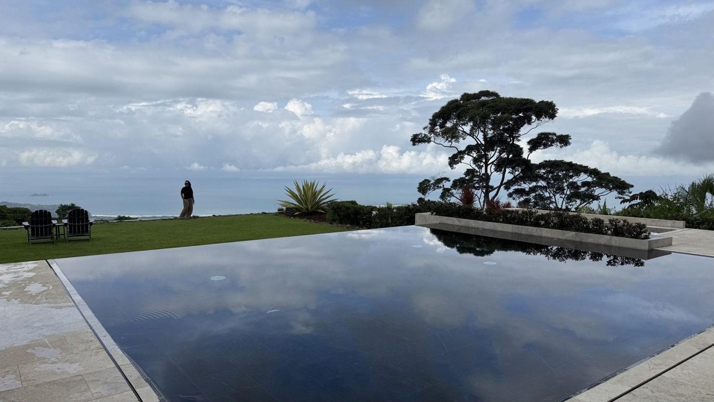 Piscina de borda refletindo a mata