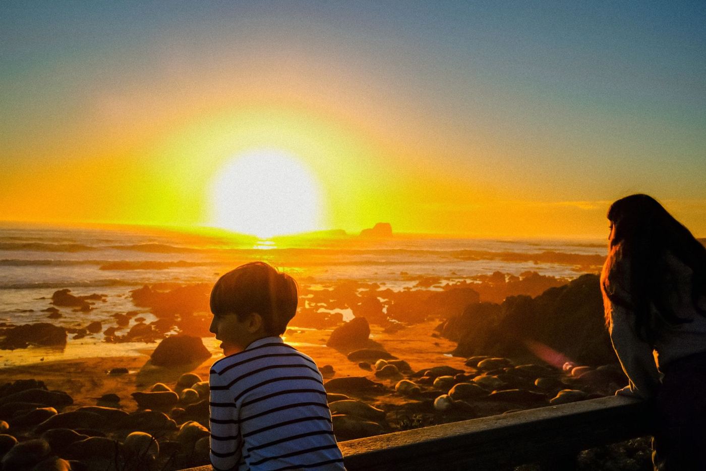 Pôr do sol no Pacífico com a família em silhueta