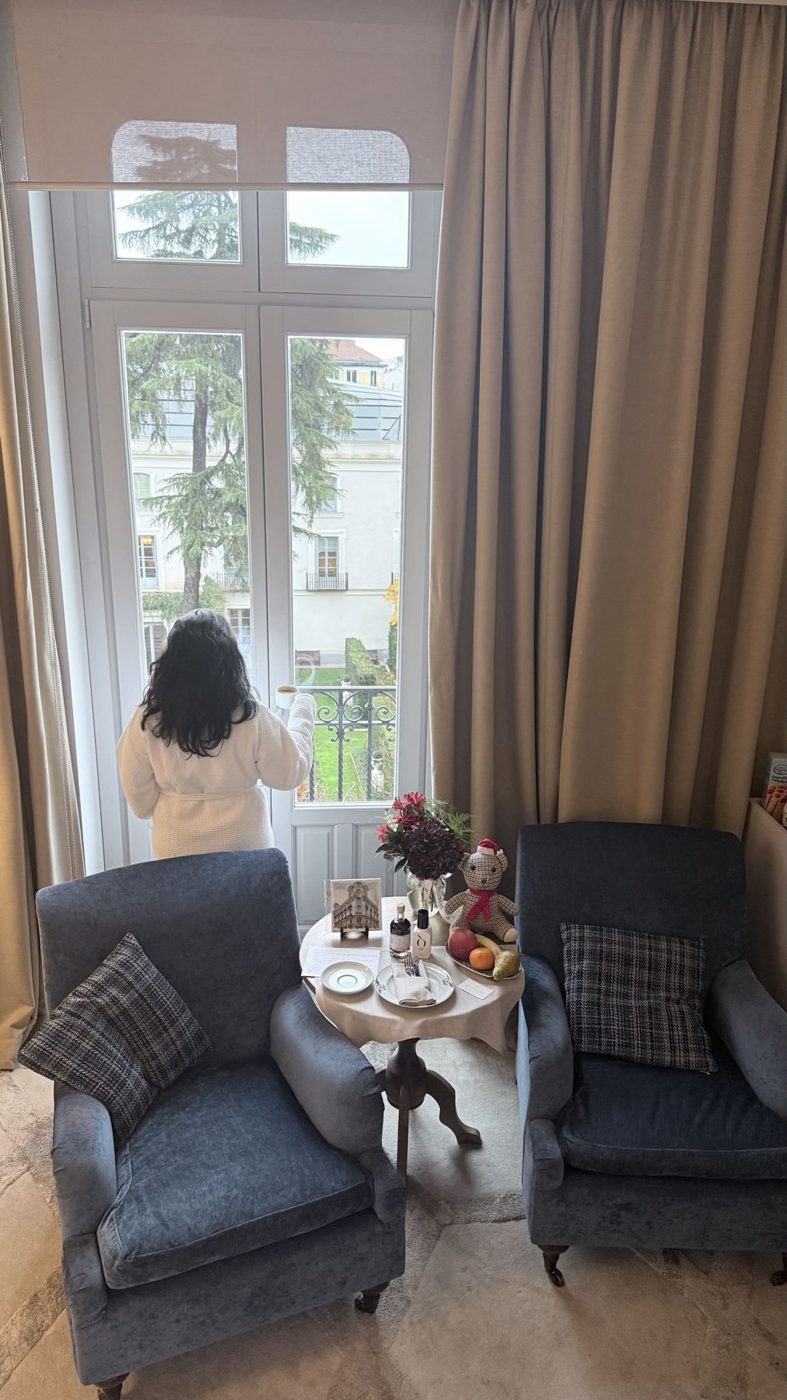 Hóspede de roupão de costas na janela do Hotel Urso