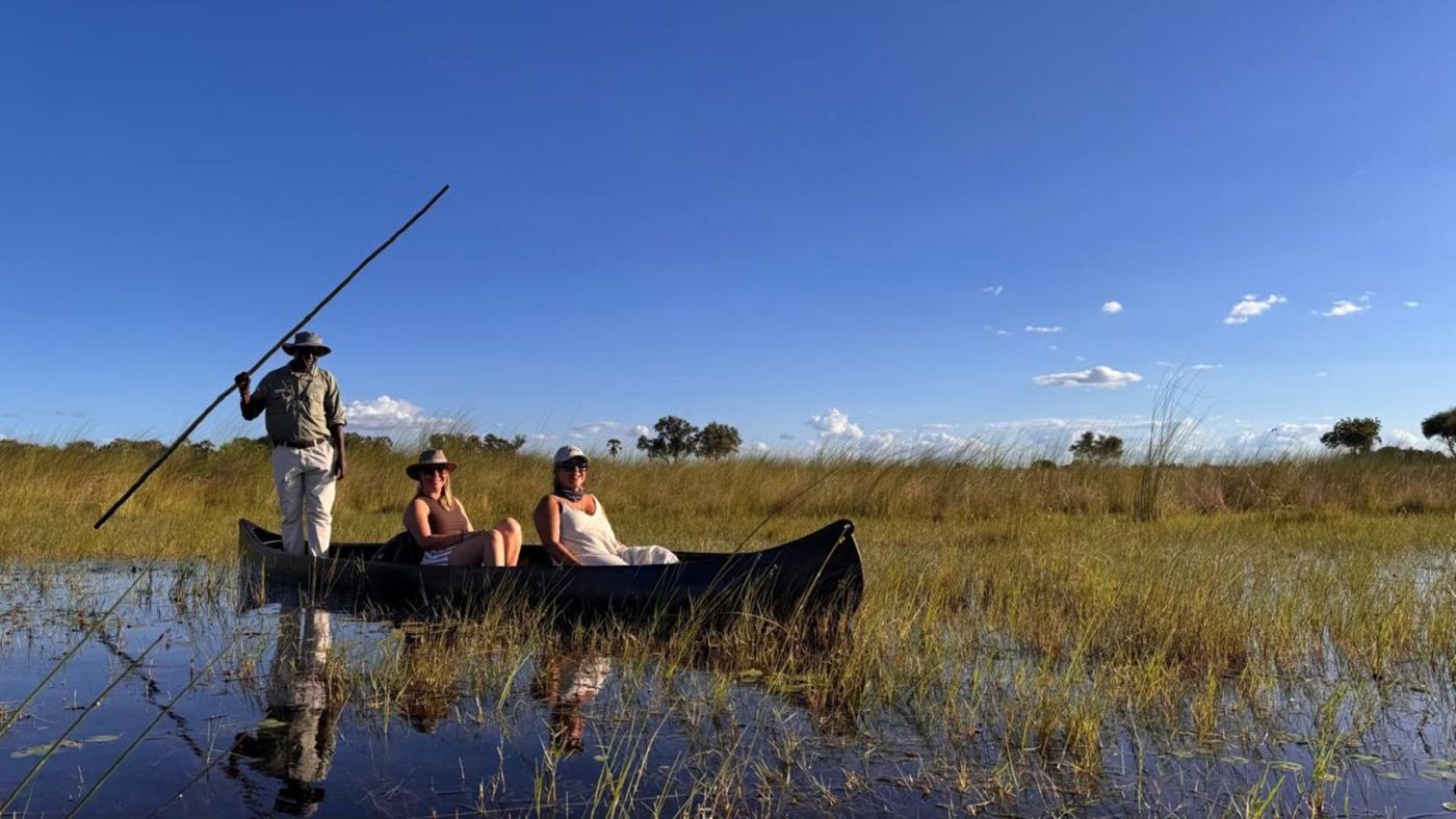 Mokoro com guia em pé entre os juncos do Delta do Okavango