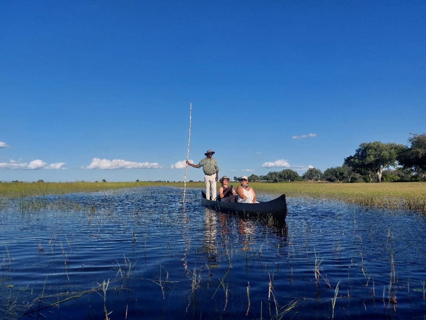 Mokoro deslizando em água espelhada no Delta do Okavango