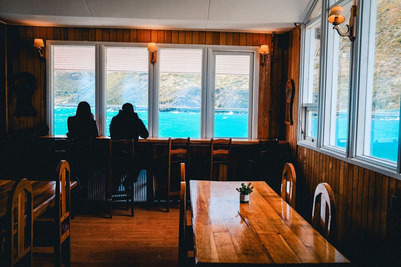 Salão de madeira do lodge com janela para o lago
