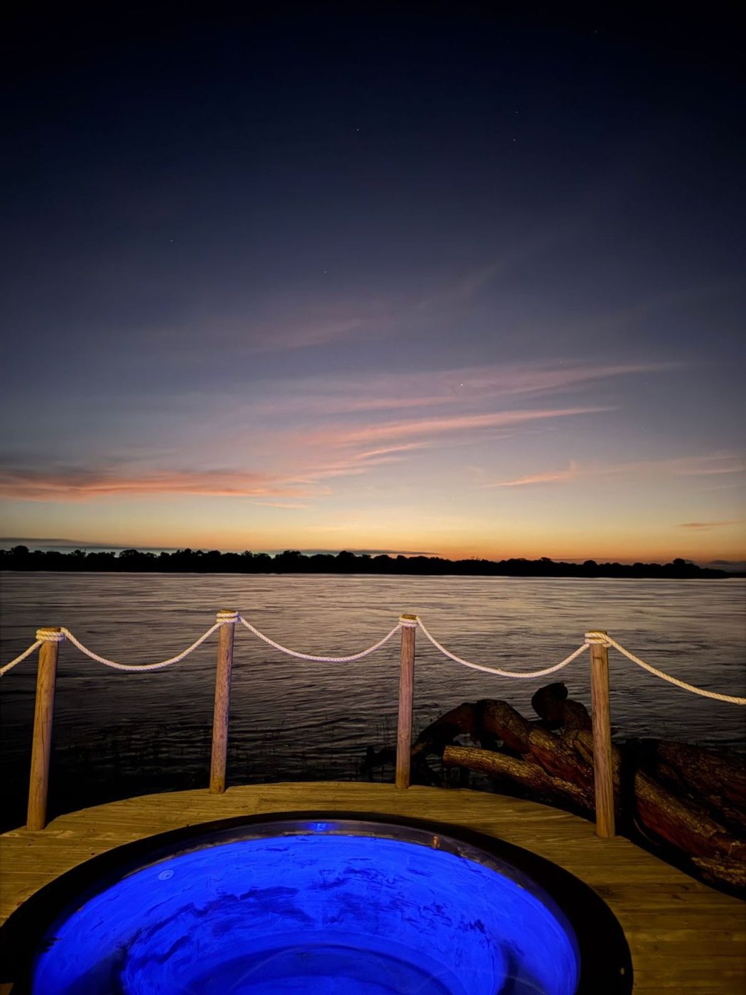Jacuzzi iluminada no deck ao crepúsculo